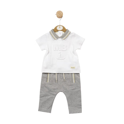 This Mintini Baby boys' polo shirt and trouser set is perfect for any occasion. The white polo t-shirt features a stylish grey collar with yellow and white piping detail, along with the MB logo on the middle on the shirt. The grey trousers offer both comfort and functionality with pockets and a drawstring fastening. Elevate your little one's wardrobe with this fashionable two piece set. Available in sizes 3 month up to 5 year old.
