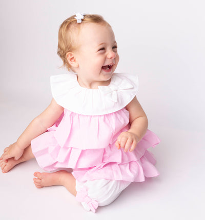 This Mintini Baby branded two piece set is perfect for your little girl this spring and summer. Featuring a pink and white gingham ruffled top with a charming white collar and bow, and white bloomer shorts with adorable pink bows. Available in sizes 3 months to 24 months.