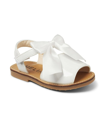 These girls' summer sandals offer a fashionable twist on the classic menorcan style shoe. With a shiny white patent finish, velcro strap, and elegant bow detail, these sandals are the perfect addition to any summer wardrobe. Step out in style and comfort with these adorable shoes.