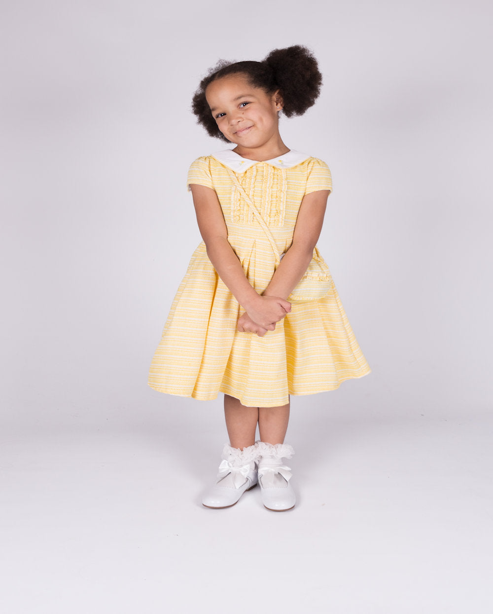 This girls' lemon short sleeve dress from Beau Kid is perfect for the spring/summer season. Made with a small collar and small box design on the front, it's part of our latest collection and comes with a matching handbag. Available in sizes 1-2 year old up to 7-8 year old.