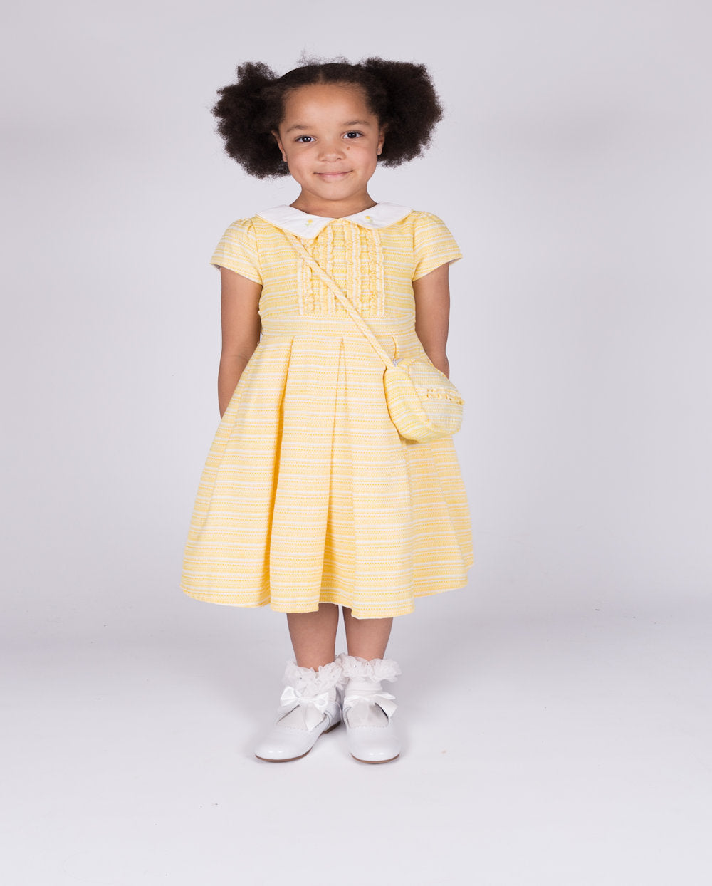 This girls' lemon short sleeve dress from Beau Kid is perfect for the spring/summer season. Made with a small collar and small box design on the front, it's part of our latest collection and comes with a matching handbag. Available in sizes 1-2 year old up to 7-8 year old.