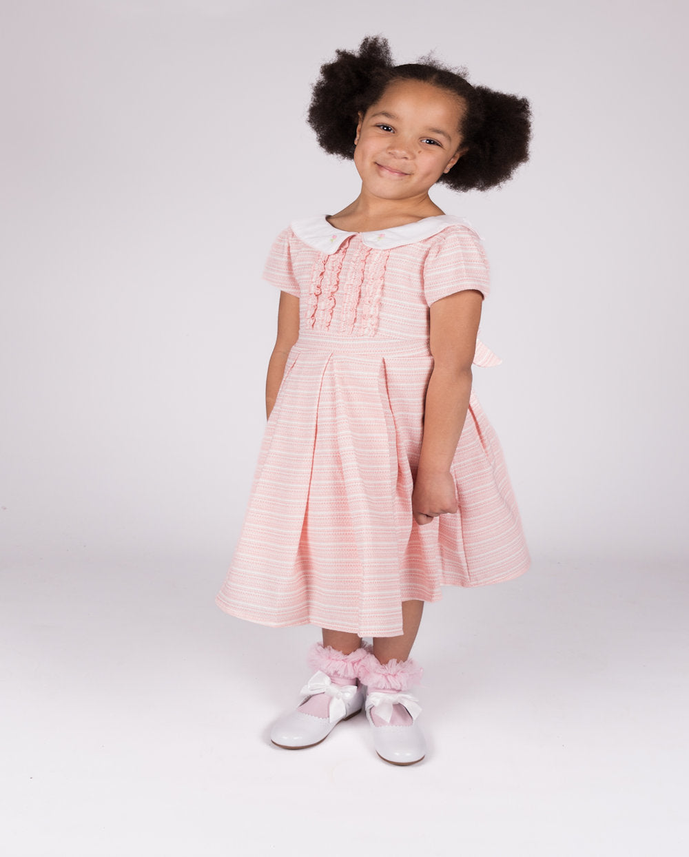 This girls' pink short sleeve dress from Beau Kid is ideal for the warmer seasons. Featuring a small collar and a small box design on the front, it is part of our newest collection and includes a coordinating handbag. Sizes range from 1-2 years old to 7-8 years old, making it suitable for various age ranges.