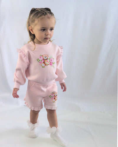 Introducing the Beau Kid girls pink two piece knitted teddy bear short set. This adorable new season arrival from our spring summer collection is perfect for your little one. Made with soft, knitted fabric, the set features a teddy motif design on the top and on the shorts, and has frill details on both the top and shorts. Available in sizes 2-3 years up to 8-9 years old.