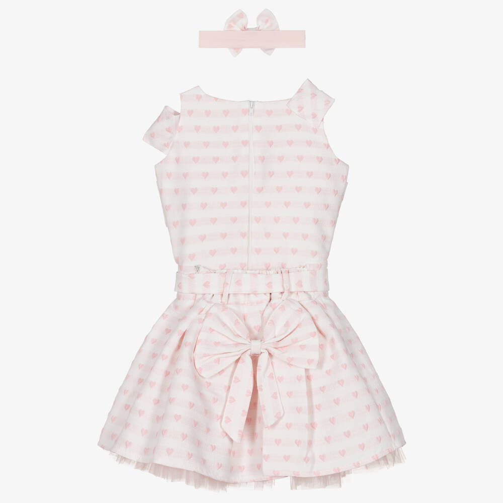 A detailed close-up of the Beau Kid top featuring a pink heart appliqué outlined with white pearl beads and an inner embroidered heart with floral accents.