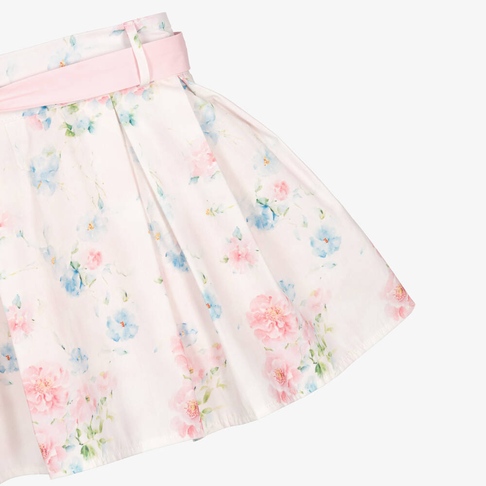 Side profile shot of the Beau Kid botanical rose dress, illustrating the above-the-knee length, ruffled sleeves, and the voluminous flare of the box-pleated skirt.