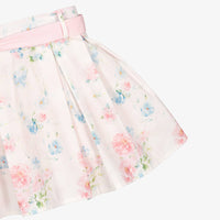 Side profile shot of the Beau Kid botanical rose dress, illustrating the above-the-knee length, ruffled sleeves, and the voluminous flare of the box-pleated skirt.