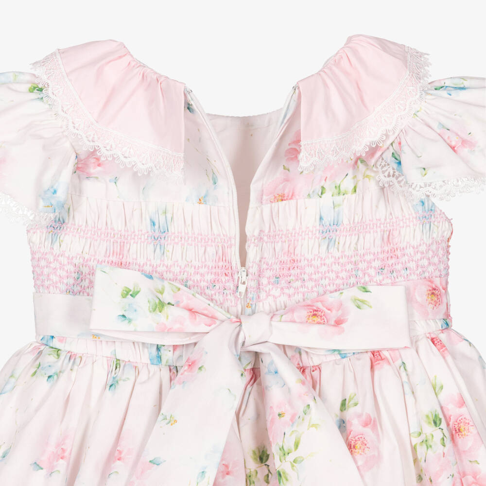 Side profile of a girl wearing the Beau Kid ivory botanical dress, illustrating the above the knee length and full-skirted volume.