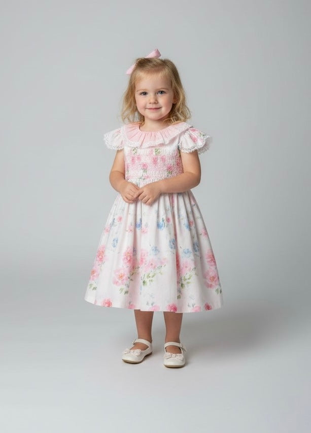 A high-definition close-up of the Beau Kid ivory cotton fabric, showcasing the vibrant pink rose and blue botanical floral print with lush green foliage detail.
