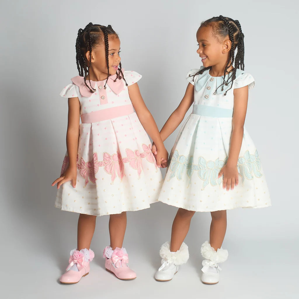 Group shot of the Beau Kid girls brocade ruffle dresses in sage green and pink, showing the matching boutique lace detailing and floral textures.