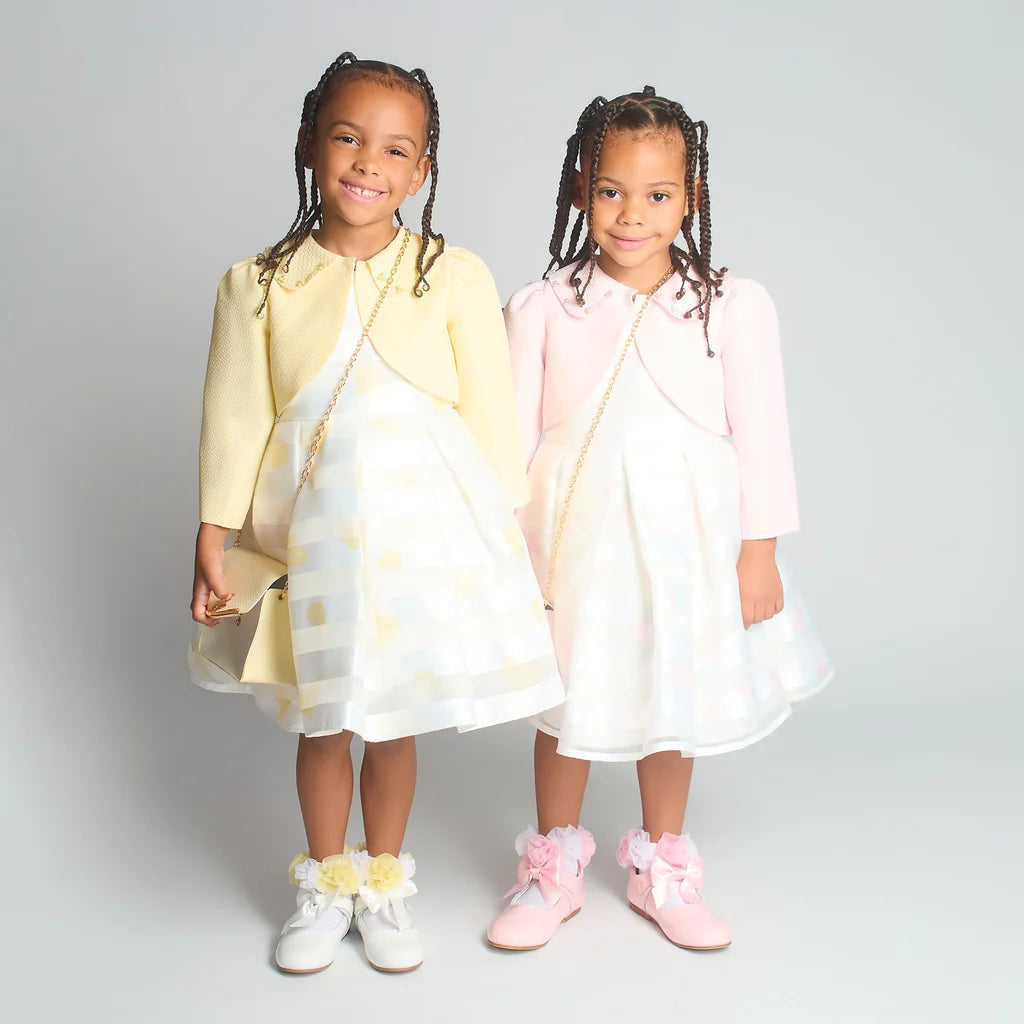 Combined studio shot of the Beau Kid girls jacquard dress sets in both lemon and pink, highlighting the matching boutique accessories.