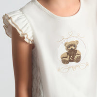 A close-up image of the Beau Kid camel jersey top highlighting the teddy bear motif and the 3D fabric bow embellishment.