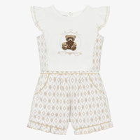 Front-facing studio shot of the Beau Kid boys 2-piece set featuring a white short-sleeved polo shirt with camel brown accents and matching tailored chino-style shorts.