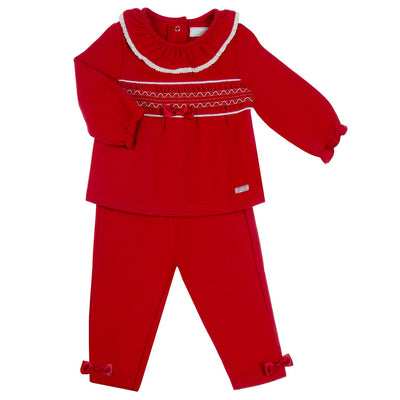 Introducing the Amore branded girls red smocked top &amp; legging set, the perfect outfit for your little one this Christmas! This two piece outfit features a stunning smocked design, with a frilly neck and a charming silk ribbon bow detail in the middle. Available in sizes 0-3 months up to 18-24 months.