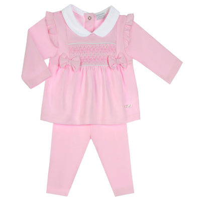 Expertly crafted for your little princess, our Amore branded girls pink two piece smocked set is perfect for any occasion. The smocked design, adorned with two charming bows, adds a touch of elegance, while the frill design on the shoulders and white collar detail add a playful touch. Available in sizes 0-3 months to 18-24 months.