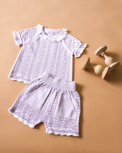 <p>Experience the trendy Leo King branded baby girls lilac short set for the spring and summer season. Made from plush cotton, this set includes a short sleeve top with a white lace collar and stretchy cuffs, as well as cosy elasticated shorts. Available in sizes 3-6 months to 12-18 months.</p>