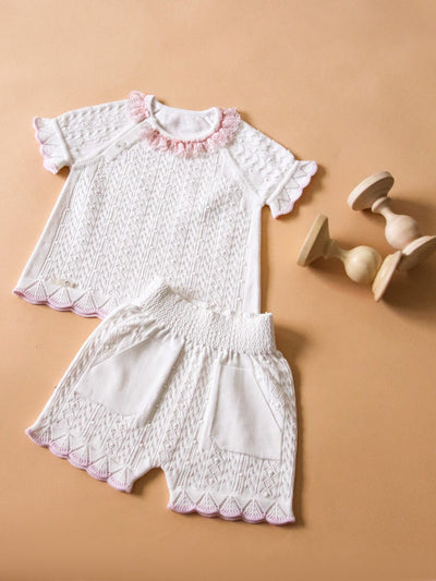 <p>Introduce your little one to the stylish spring and summer collection with our Leo King branded baby girls white short set. Made with natural cotton, this two piece set includes a white short sleeve top with a delicate pink lace collar detail and elasticated cuffs, paired with elasticated shorts for extra comfort. Available in sizes 3-6 months up to 12-18 months.</p>