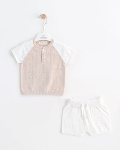 <p>Experience the best of spring and summer fashion with our Leo King branded boys short set. This elegant two piece set features a knitted ivory and beige top along with ivory shorts, complete with an elasticated waistband. The matching top boasts a round neck collar and short sleeves, adding a touch of sophistication to your little one's wardrobe. Made from 100% cotton and available in sizes ranging from 6-9 months up to 18-24 months, this set offers both style and comfort for the warmer months ahead.</p>