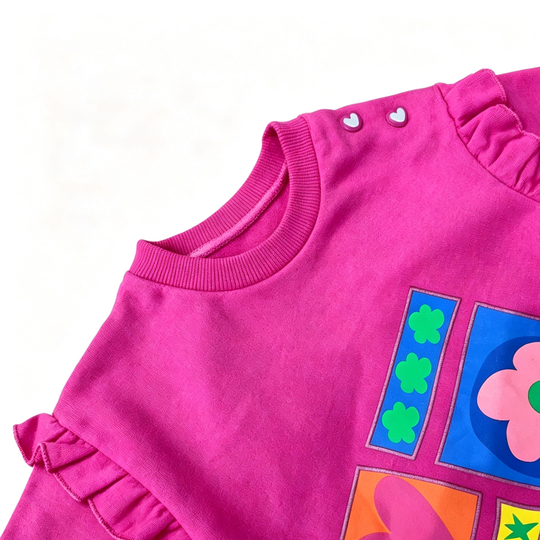 close up of girls fuchsia pink sweatshirt shoulder ruffles and heart buttons