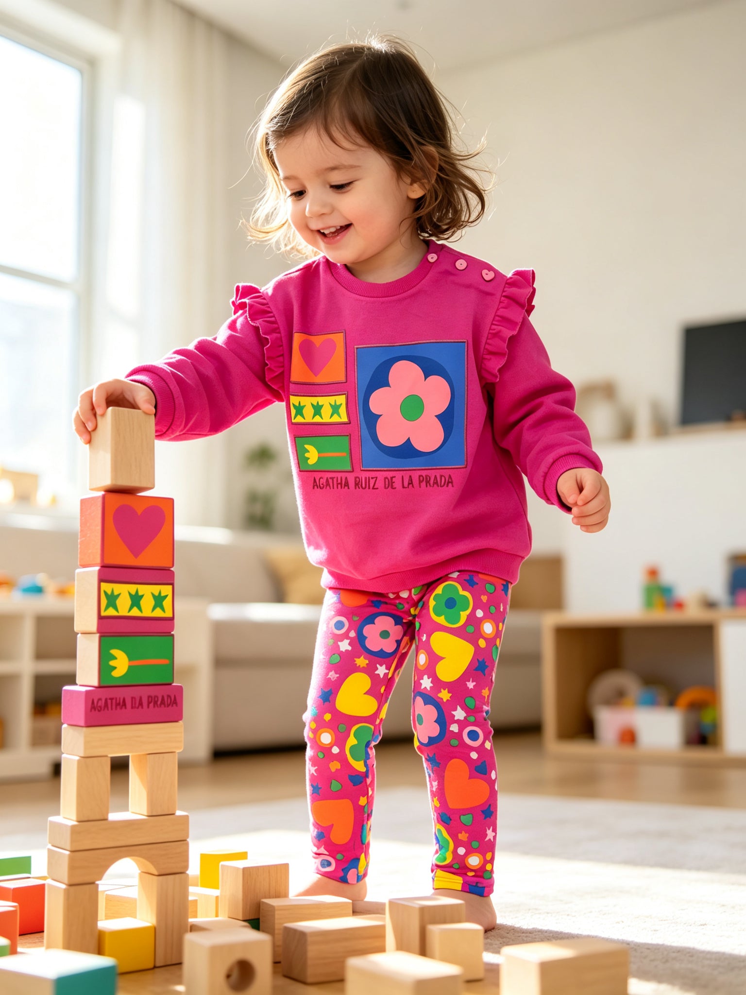 toddler playing with wooden blocks wearing agatha ruiz de la prada sweatshirt and leggings set