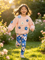 toddler running happily in a sunny garden wearing agatha ruiz de la prada pink quilted top and floral leggings