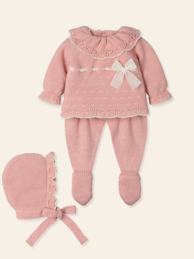 This three piece set from Mac Ilusion is a must-have for autumn and winter. This baby girls' dusty pink outfit includes a top, trousers, and bonnet with a beige bow detail. Made by the popular Spanish boutique brand, it is perfect for your little princess. Ideal baby girl outfit if you are looking for a special gift for a baby shower or newborn baby girl present as it comes in a gift box too. Available in sizes 1 month, 3 months, and 6 months.