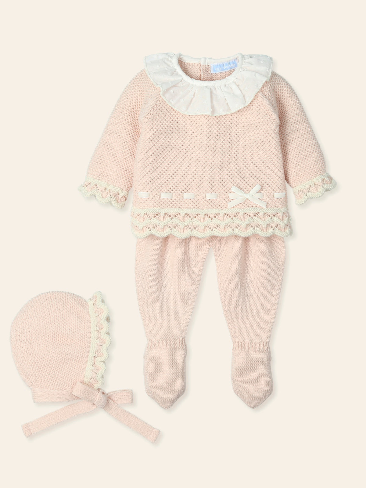 Introduce your little one to the autumn/winter season in style with this baby girls nude three piece knitted set by Spanish children's clothing brand, Mac Ilusion. This new arrival in our branded collection offers a cosy and chic outfit for your baby girl, featuring a long sleeve top with charming frilly collar details and bow detail across the bottom. Comes with a matching bonnet. Available in sizes 1, 3 and 6 months and comes in a gift box, making it perfect for a baby shower gift or a newborn baby girl p