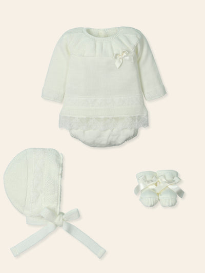 This Mac Ilusion branded baby girls four piece knitted set in cream is perfect for your little one. The set includes a long sleeve top with delicate lace and bow details, culotte shorts with a comfortable elasticated waistband, a bonnet that fastens, and cute matching booties. Available in sizes 1 month, 3 months, and 6 months. Comes in a gift box for easy gifting.