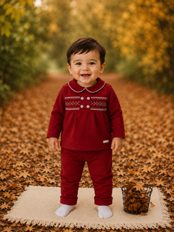amore boys red smocked top and trousers set model standing on autumn leaves luxury toddler outfit