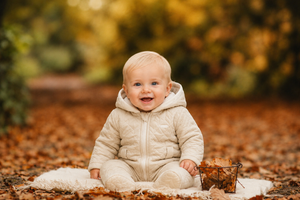 amore baby boys beige quilted pram suit model sitting in autumn leaves luxury infant fashion