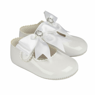 So cute for little girls, a white patent pair of pre-walker baby girl shoes made from soft patent faux leather, with soft faux leather soles. Part of our Baypods collection, these adorable shoes fasten with a small button strap and have large ribbon bows and diamanté trims.  . Soft patent faux leather uppers Soft, faux leather, lightly cushioned sole Button strap fastening 