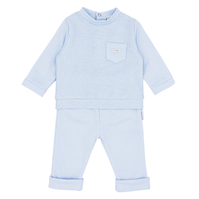 Blues Baby branded boys two piece jog set finished in a lovely pastel blue American fleece fabric. This set consists of a round neck top with a small pocket detail to the front, and comes with matching trousers. Available in sizes 3 month up to 24 month.  Also available in navy blue.