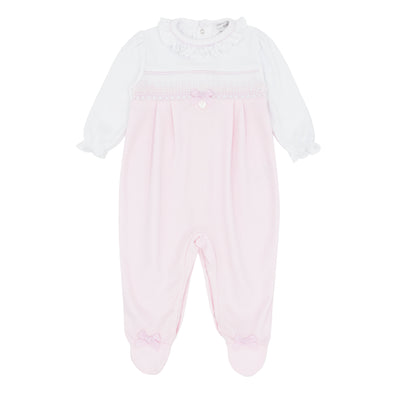 Introducing Blues Baby's all-in-one sleeper for girls. Finished In soft pastel pink and white colour combination. This classic smocked design babygrow with ribbon bow is perfect for newborns up to 3 months old. Features a frilly round neck collar for added cuteness. Expertly crafted, get yours now!