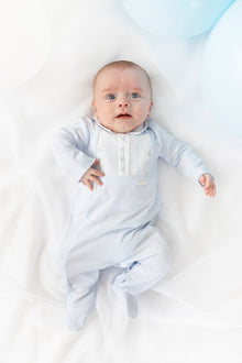Close up of Blues Baby Cannes sleepsuit showing intricate white smocked chest detail and smart pointed collar