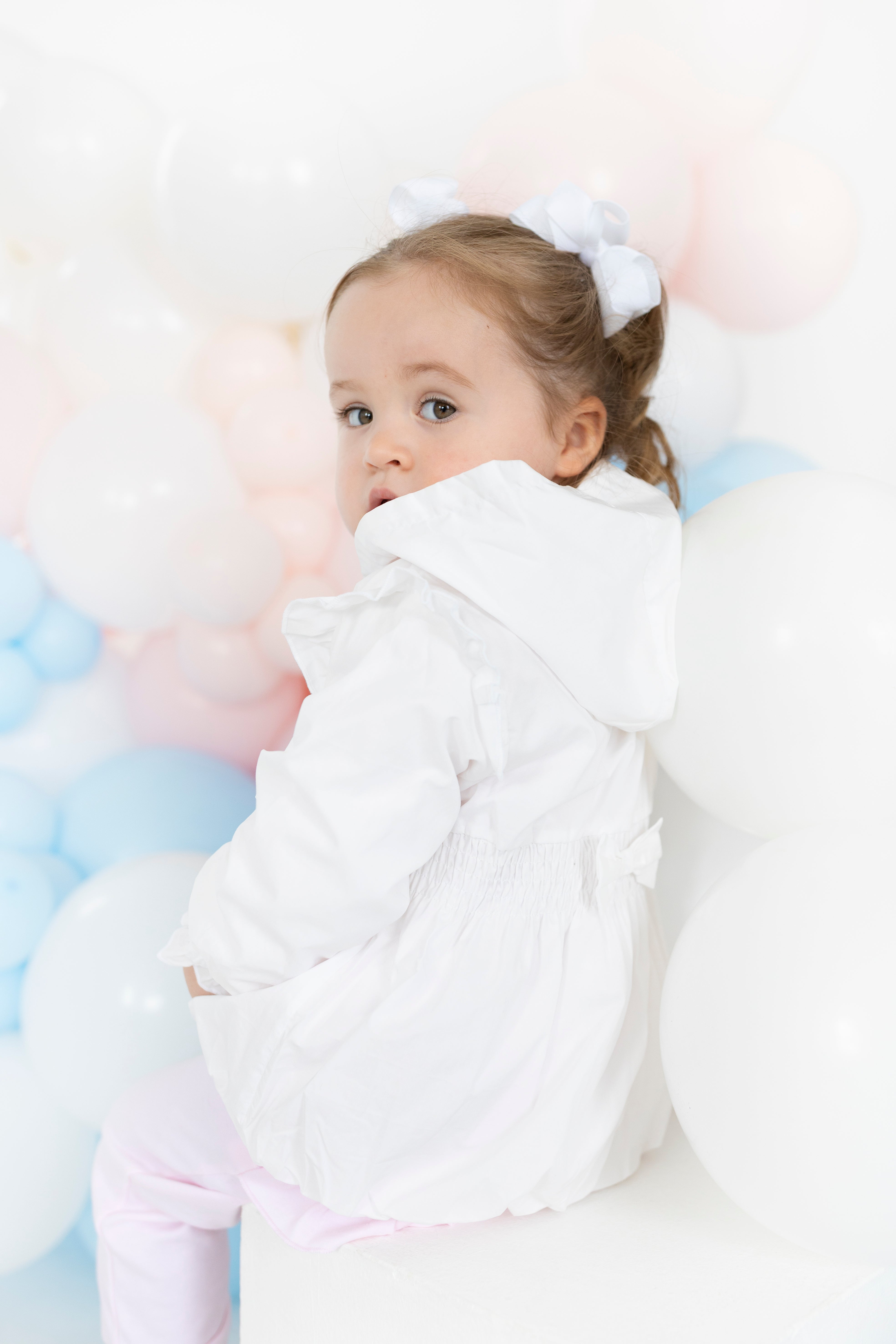 Blues Baby girls white spring summer jacket with hood and smocked waist on a young girl