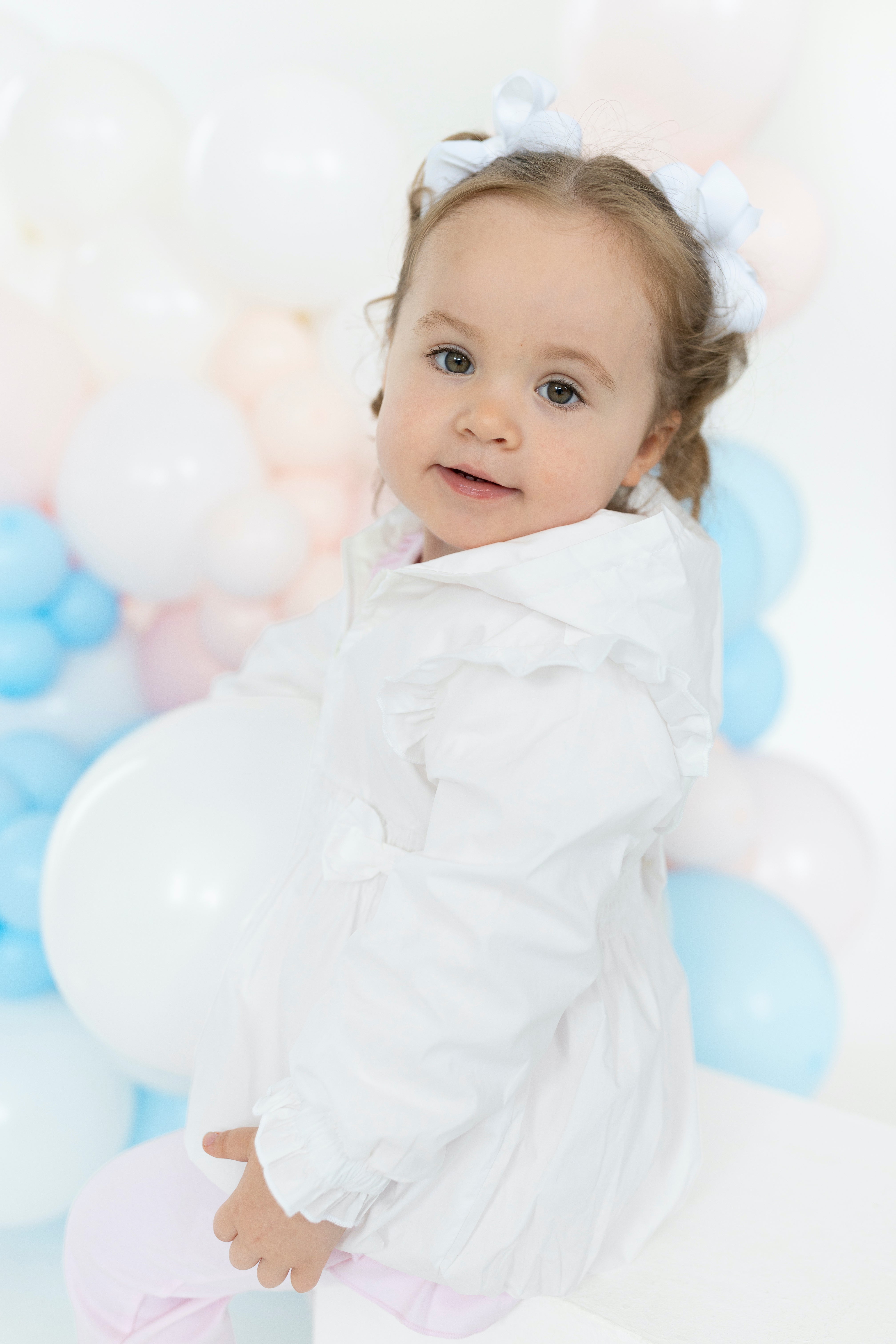 Side view of Blues Baby white La Rochelle jacket showing ruffle shoulder detail and elasticated frill cuffs