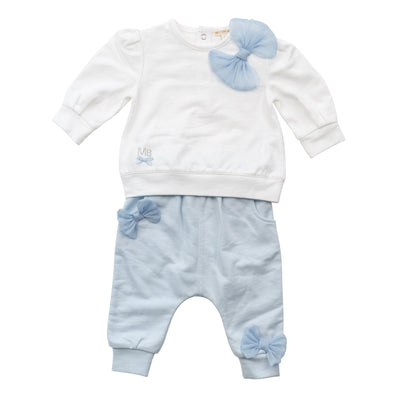 Introduce your little fashionista to our latest arrival, the girls white &amp; blue two piece jogger set with bow detail from Mintini Baby. This adorable set includes a white long sleeve top with a charming blue bow detail, paired with blue joggers featuring a matching bow on the leg. Available in sizes 3 months to 24 months, this set is perfect for your stylish baby girl.