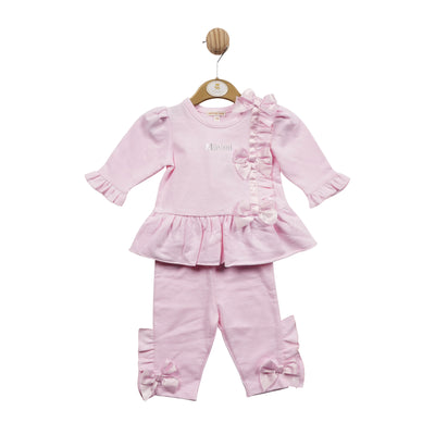 Mintini Baby branded girls two piece top and legging set finished in a pastel pink colour. This set consists of a round neck, long sleeve top, which has silk bows going down the side on the front. It comes with leggings to match which also have the bows on the ankles. Available in sizes 3 month up to 24 month.