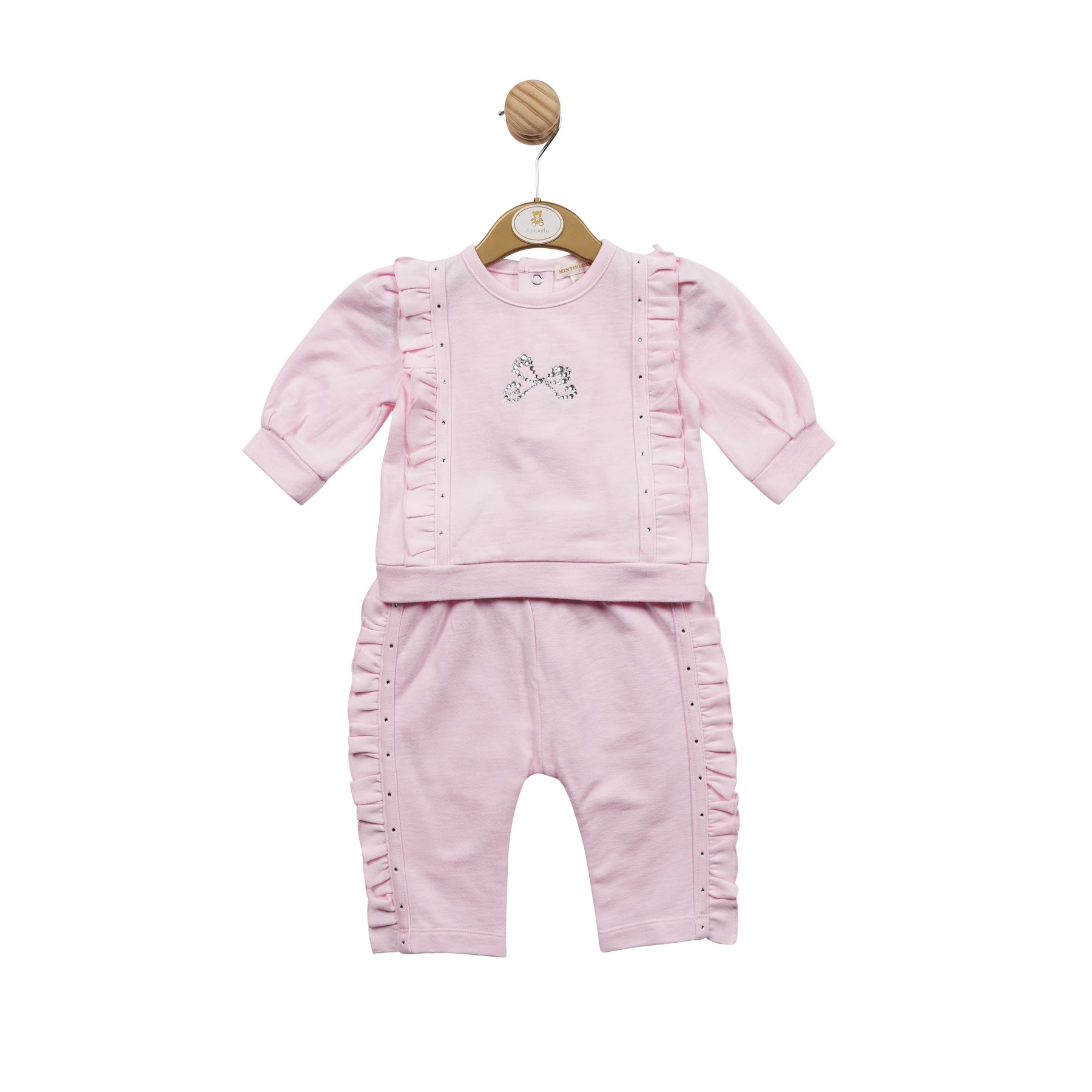 This stylish two piece set from Mintini Baby will have your little girl looking adorable. The soft pink set features a top with a diamanté bow detail and comfortable jogger trousers. Available in sizes 3 month up to 24 month. Sophisticated and sweet looks like this are hard to resist.