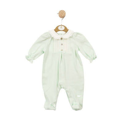 This Mintini Baby girls all in one sleepsuit is a must-have for your little one's sleepwear collection. The mint green colour and smocked design add a touch of charm, while the frilly white collar and button detailing with a small bow make it extra adorable. Available in sizes 1 month, 3 month & 6 month.