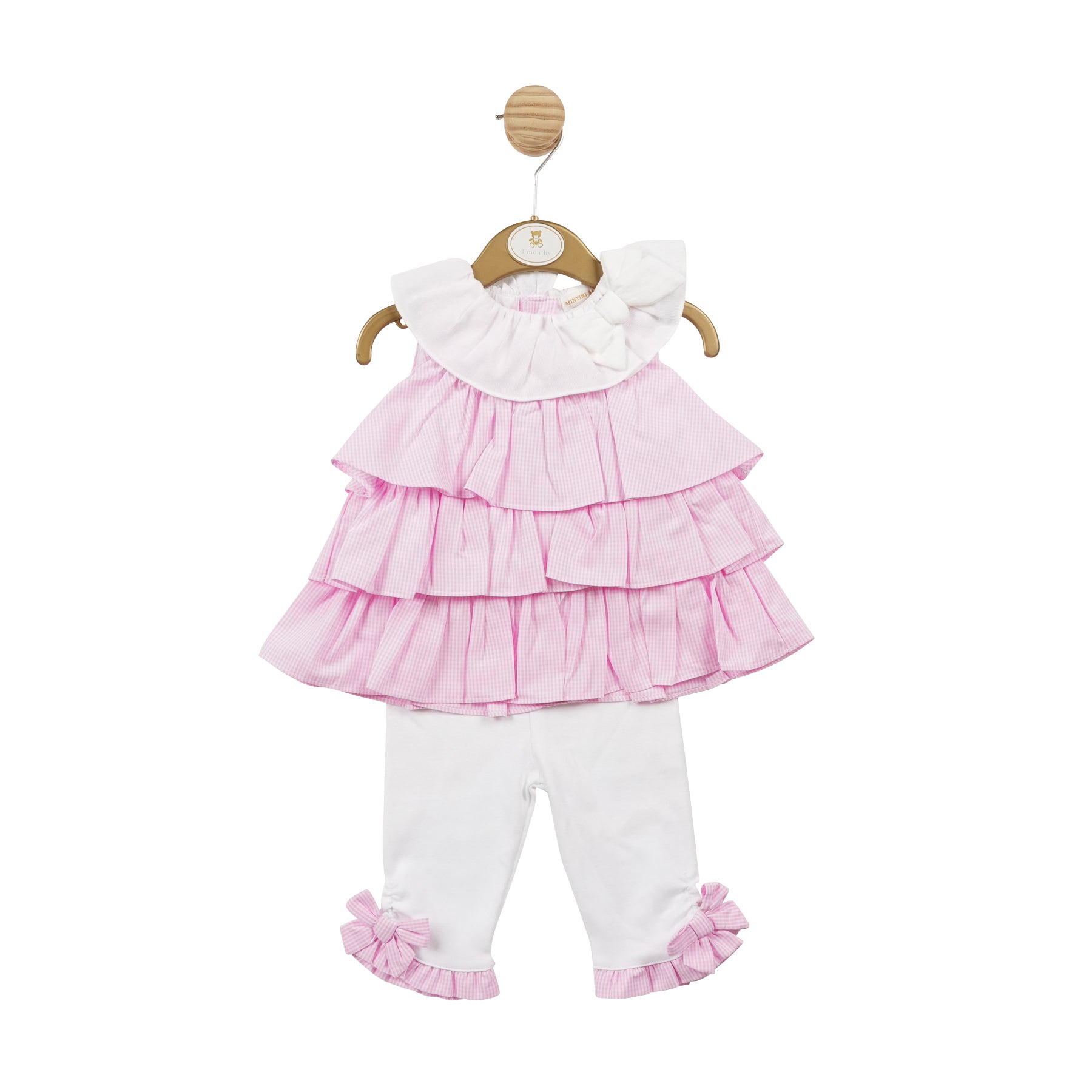 This Mintini Baby girls' tunic and legging set is perfect for spring and summer. The soft pink and white gingham pattern is both adorable and stylish, making your little one stand out. The top is ruffled with a white collar and bow detail, and the leggings are in white with pink frill and bow detail around the ankle. With sizes from 3 months up to 5 years old, this set is ideal for matching sisters and can be worn for any occasion.