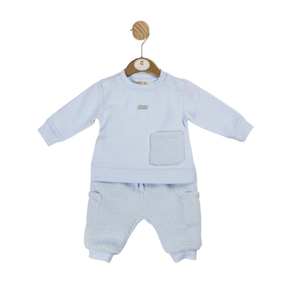 Introduce your little one to Mintini Baby's latest addition - the boys blue two piece towelling jogsuit! Perfect for the autumn winter season, this stylish jogger outfit features a long sleeve top with a pocket design on the front made from towelling fabric. The joggers are made of a towelling fabric, this outfit is available in sizes 3 months up to 24 months.