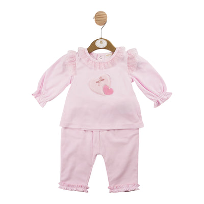 This girls pink heart motif top &amp; trouser set from Mintini Baby's autumn winter collection is a must-have for your little one. The boutique style outfit features a long sleeve top with a cute heart motif and frill detail on the shoulders, paired with matching trousers. Available in sizes from 3 months up to 24 months, this set is perfect for any occasion.