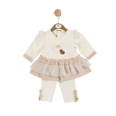 This two piece set from Mintini Baby is perfect for your little girl. The long sleeve top features a delicate heart detail and a beige frill at the bottom, while the matching ivory leggings complete the look. Finished in beige, ivory, and gold, this set is available in sizes from 3 months to 5 years old. Perfect if your looking for matching little sister and big sister outfits.