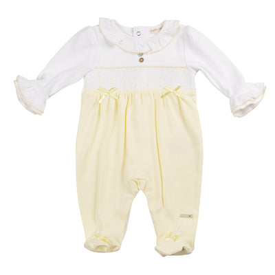 This baby girls lemon &amp; white smocked all in one sleepsuit by Mintini Baby is perfect for your little one. This adorable sleeper features a smocked band across the chest, a small cute bow detail, and a frilly collar and cuffs for a touch of charm. With a push button fastening on the reverse, dressing and changing is made easy. Available in sizes 1 month, 3 months, and 6 months.