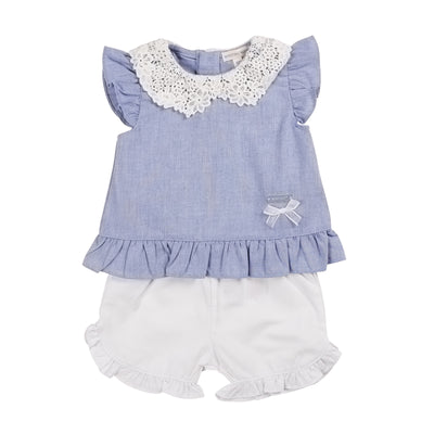 Get your little one ready for spring and summer with our girls blue &amp; white two piece top and shorts set from childrenswear boutique brand, Mintini Baby. This stylish outfit features a blue top with short sleeves and a crochet-style neck design, paired with white elasticated shorts with frill detail. Available in sizes 3 months to 5 years, it's the perfect choice for a matching little sister and big sister look. Upgrade your little girl's fashion game today!