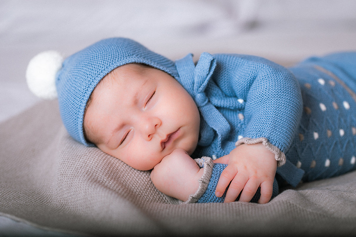 Introducing our baby boys blue spot detail three piece set by Mac Ilusion. part of our autumn / winter collection. This Spanish boutique brand offers a stunning dark blue set with grey and white spot detail on the top with grey trim around the cuffs and bottom of the top, complete with a round neck collar and long sleeves. This set includes closed feet trousers and a matching hat with a bobble. Available in sizes 1 month, 3 months, and 6 months. Comes presented in a gift box making it perfect as a baby boy 