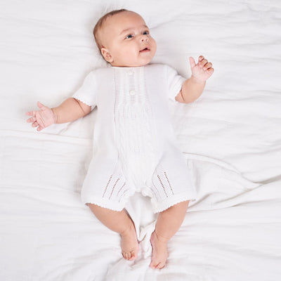 <p>This beautifully designed traditional white romper for baby boys is crafted with expertise by Dandelion. Its acrylic knit material adds a touch of elegance and charm, while the intricate knitted pattern on the front adds to its appeal. Made with precision in Portugal, it is offered in two charming colours - white and blue, and is available in sizes newborn, 0-3 months, 3-6 months, and 6-12 months.</p>