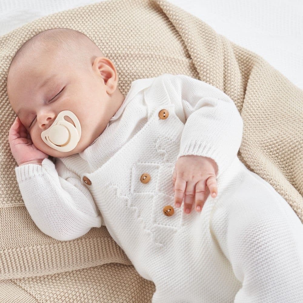This white knitted dungaree & top set from Dandelion is crafted with quality materials that offer long-lasting comfort, with its unisex design it is suitable for both a baby boy or a baby girl. The set includes a knitted dungaree and a long sleeve top, both featuring a pique peter pan collar on the jumper and two wooden buttons for easy dressing. Ideal for special occasions or everyday wear.