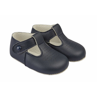 These navy pre-walker baby shoes, from our Baypods collection, are beautifully made in soft faux leather and have a dainty holed pattern on the toes. In a t-bar style, they are easy to put on and secure with a button fastening strap. They have a lightly cushioned insole and their flexible soles are just right for developing feet.  . Faux leather Lightly cushioned insole  Flexible soles Button fastening strap Shoes suitable for boys & girls