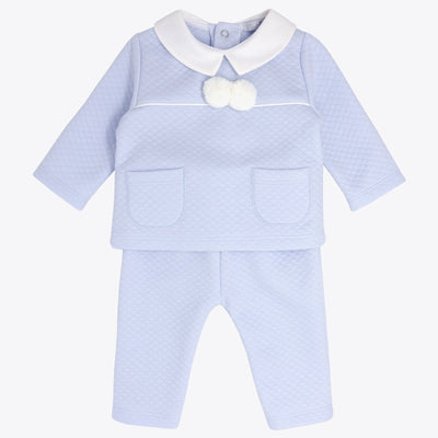 Blues Baby branded boys pastel blue two piece trouser set, finished in a diamond jacquard design. This top has white collars with two white pom pom, and two pockets on either side of the top. Push button fastening on the reverse. This is set available in sizes 3m, 6m, 9m, 12m, 18m & 24m. True to size.